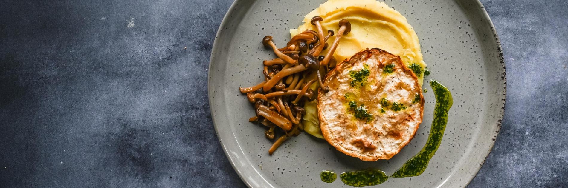 Celeriac steak with mashed potatoes, beech mushroom & herb oil
