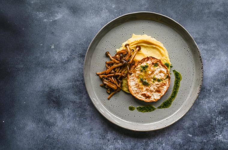 Celeriac steak with mashed potatoes, beech mushroom & herb oil