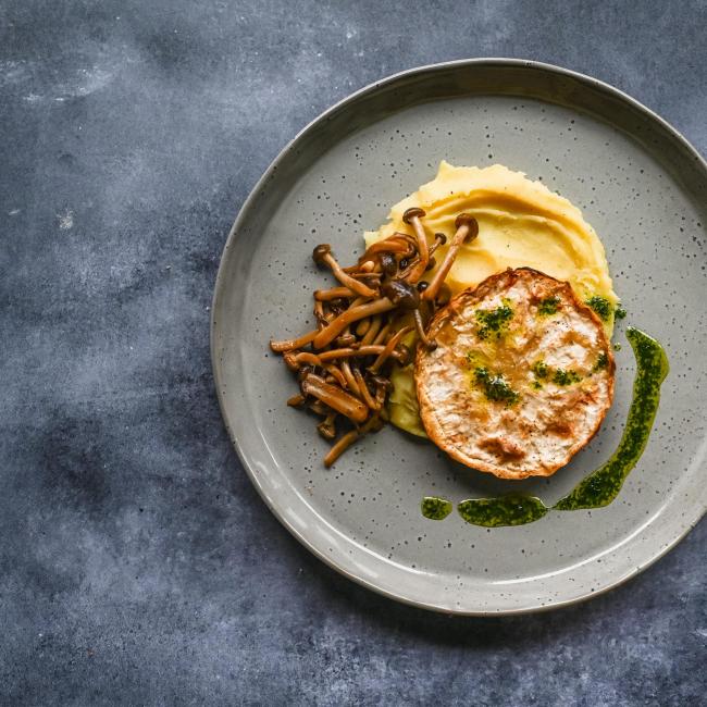 Celeriac steak with mashed potatoes, beech mushroom & herb oil